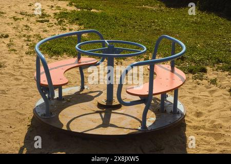 Ein Karussell oder Karussell auf einem Spielplatz auf Sand Stockfoto