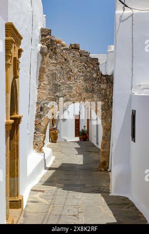 Typisch griechische Dorfstraße, Häuser mit weißer Außenwand und Tuffsteinbogen, Lindos rhodos Sommerferienziel Stockfoto