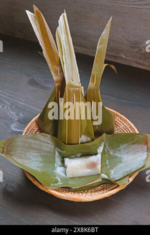 Gedünstetes thailändisches Dessert aus Reismehl mit gesüßter Kokosraspel, umwickelt in Bananenblatt namens Khanom Sai Sai Stockfoto