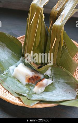 Köstliches Khanom Sai Sai, gedämpftes thailändisches Dessert aus Reismehl mit gesüßter Kokosraspel-Füllung, umwickelt in Bananenblatt Stockfoto