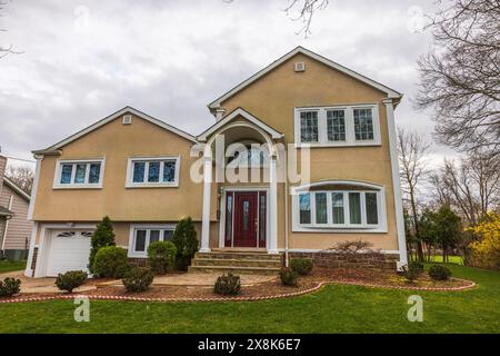 Wunderschöner Blick auf eine moderne Villa mit Blick auf einen Frühlingsgarten vor einem bewölkten Himmel. New Jersey. USA. Stockfoto