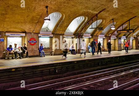Londoner U-Bahn-Station, alte Baker Street Station, Backsteinmauern und Leute, die auf dem Bahnsteig warten Stockfoto