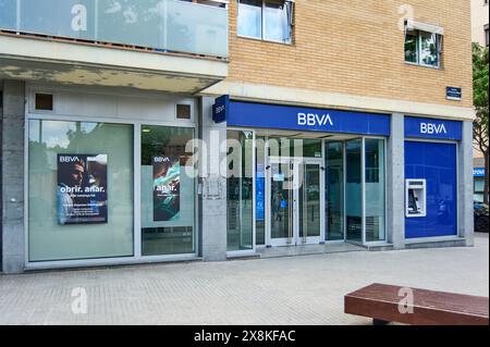 Viladecans, Barcelona, Spanien-26. Mai 2024: Moderne Fassade einer BBVA-Niederlassung in Spanien mit Glaseingang und Geldautomat. Der Bürgersteig der Stadt und ein Holz Stockfoto