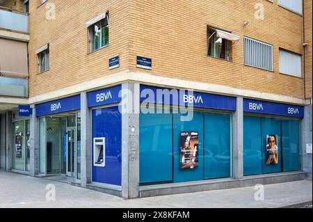 Viladecans, Barcelona, Spanien-26. Mai 2024: Fassade einer BBVA-Bankfiliale mit Glaseingang und Geldautomat. Die Bank befindet sich in einem Stadtgebiet mit Sockel Stockfoto