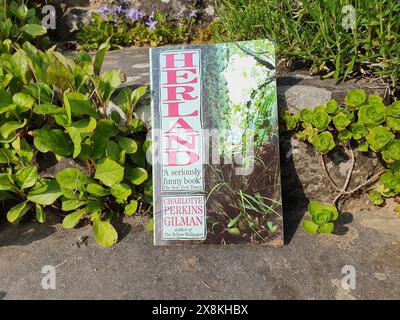 Herland Roman von Charlotte Perkins Gilman Buch in einer Gartenlandschaft Stockfoto