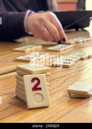Nicht identifizierte Menschen (Hände) spielen Rommé-Spiel an einem Holztisch in Buenos Aires, Argentinien Stockfoto