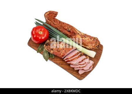 Schweinefilet Pastrami geräuchert und gewürzt, mit dünnen Scheiben, Tomaten und Frühlingszwiebeln, auf einem Holzschneidebrett, isoliert auf weiß Stockfoto