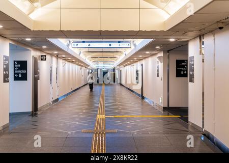 Fußgängerunterführung unter einer Hauptstraße und Verkehrsknotenpunkt in Kumamoto, Japan. Der Tunnel verfügt über Toiletten, taktile Pflastersteine und Rolltreppe. Stockfoto