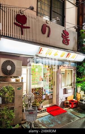 Chinesisches Restaurant am Abend in Otsuka, Tokio. Vorderseite des Restaurants mit Eingangstür und Klimaanlage draußen auf dem Bürgersteig. Stockfoto