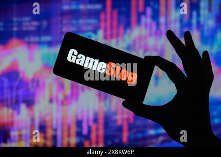 Brüssel, Belgien Mai 2024. Das GameStop-Logo wird auf einem Smartphone mit einer Bestandsgrafik angezeigt, die auf dem Bildschirm im Hintergrund in dieser Fotoabbildung sichtbar ist. Aufgenommen in Brüssel, Belgien. Am 25. Mai 2024. (Jonathan Raa/SIPA USA) *** ausschließlich für redaktionelle Nachrichten *** Credit: SIPA USA/Alamy Live News Stockfoto