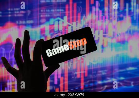 Brüssel, Belgien Mai 2024. Das GameStop-Logo wird auf einem Smartphone mit einer Bestandsgrafik angezeigt, die auf dem Bildschirm im Hintergrund in dieser Fotoabbildung sichtbar ist. Aufgenommen in Brüssel, Belgien. Am 25. Mai 2024. (Jonathan Raa/SIPA USA) *** ausschließlich für redaktionelle Nachrichten *** Credit: SIPA USA/Alamy Live News Stockfoto