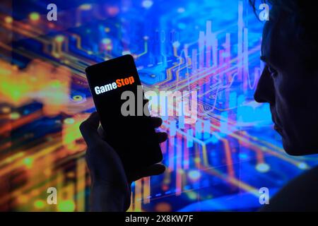Brüssel, Belgien Mai 2024. Das GameStop-Logo wird auf einem Smartphone mit einer Bestandsgrafik angezeigt, die auf dem Bildschirm im Hintergrund in dieser Fotoabbildung sichtbar ist. Aufgenommen in Brüssel, Belgien. Am 25. Mai 2024. (Jonathan Raa/SIPA USA) *** ausschließlich für redaktionelle Nachrichten *** Credit: SIPA USA/Alamy Live News Stockfoto
