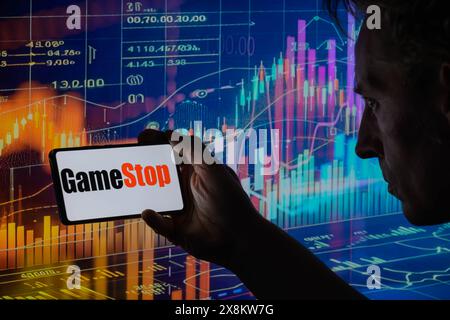 Brüssel, Belgien Mai 2024. Das GameStop-Logo wird auf einem Smartphone mit einer Bestandsgrafik angezeigt, die auf dem Bildschirm im Hintergrund in dieser Fotoabbildung sichtbar ist. Aufgenommen in Brüssel, Belgien. Am 25. Mai 2024. (Jonathan Raa/SIPA USA) *** ausschließlich für redaktionelle Nachrichten *** Credit: SIPA USA/Alamy Live News Stockfoto