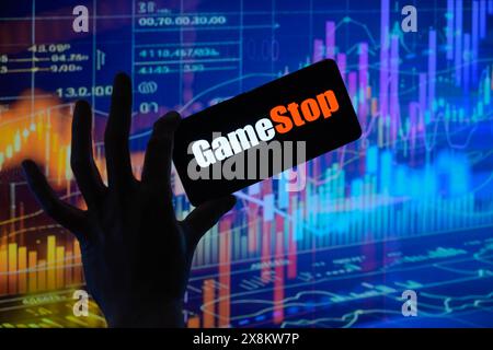 Brüssel, Belgien Mai 2024. Das GameStop-Logo wird auf einem Smartphone mit einer Bestandsgrafik angezeigt, die auf dem Bildschirm im Hintergrund in dieser Fotoabbildung sichtbar ist. Aufgenommen in Brüssel, Belgien. Am 25. Mai 2024. (Jonathan Raa/SIPA USA) *** ausschließlich für redaktionelle Nachrichten *** Credit: SIPA USA/Alamy Live News Stockfoto