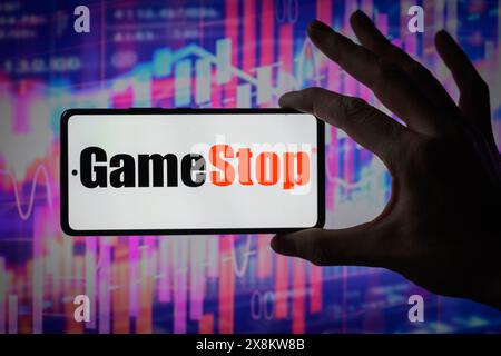 Brüssel, Belgien Mai 2024. Das GameStop-Logo wird auf einem Smartphone mit einer Bestandsgrafik angezeigt, die auf dem Bildschirm im Hintergrund in dieser Fotoabbildung sichtbar ist. Aufgenommen in Brüssel, Belgien. Am 25. Mai 2024. (Jonathan Raa/SIPA USA) *** ausschließlich für redaktionelle Nachrichten *** Credit: SIPA USA/Alamy Live News Stockfoto