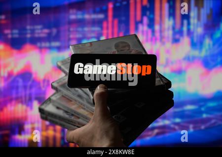 Brüssel, Belgien Mai 2024. Das GameStop-Logo wird auf einem Smartphone mit einer Bestandsgrafik angezeigt, die auf dem Bildschirm im Hintergrund in dieser Fotoabbildung sichtbar ist. Aufgenommen in Brüssel, Belgien. Am 25. Mai 2024. (Jonathan Raa/SIPA USA) *** ausschließlich für redaktionelle Nachrichten *** Credit: SIPA USA/Alamy Live News Stockfoto