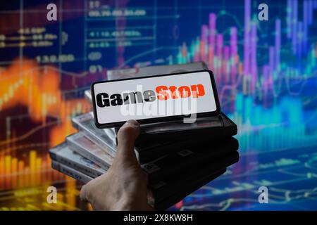Brüssel, Belgien Mai 2024. Das GameStop-Logo wird auf einem Smartphone mit einer Bestandsgrafik angezeigt, die auf dem Bildschirm im Hintergrund in dieser Fotoabbildung sichtbar ist. Aufgenommen in Brüssel, Belgien. Am 25. Mai 2024. (Jonathan Raa/SIPA USA) *** ausschließlich für redaktionelle Nachrichten *** Credit: SIPA USA/Alamy Live News Stockfoto