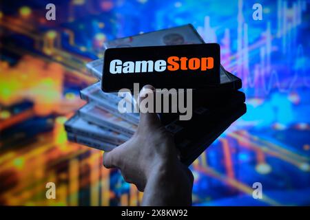 Brüssel, Belgien Mai 2024. Das GameStop-Logo wird auf einem Smartphone mit einer Bestandsgrafik angezeigt, die auf dem Bildschirm im Hintergrund in dieser Fotoabbildung sichtbar ist. Aufgenommen in Brüssel, Belgien. Am 25. Mai 2024. (Jonathan Raa/SIPA USA) *** ausschließlich für redaktionelle Nachrichten *** Credit: SIPA USA/Alamy Live News Stockfoto