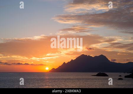 Porto, Corse-du-Sud, Korsika, Frankreich. Blick über den Golf von Porto bis zur dunklen Silhouette von Capo Senino, Sonnenuntergang. Stockfoto