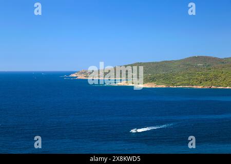 Ajaccio, Corse-du-Sud, Korsika, Frankreich. Boot überquert das tiefblaue Wasser der Anse de Minaccia in der Nähe von Pointe de la Corba. Stockfoto