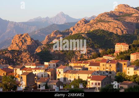 Piana, Corse-du-Sud, Korsika, Frankreich. Blick über die Skyline des Dorfes auf die hohe felsige Landschaft der Calanques, Sonnenuntergang. Stockfoto