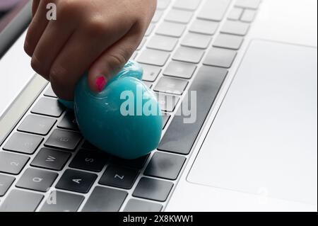 Blaues Gel-Werkzeug zum Reinigen der Tastatur in der Hand aus Nahsicht Stockfoto