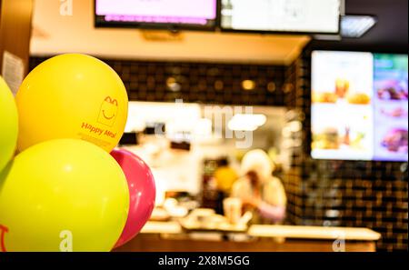 Berlin - 10. April 2023: Werbung für Happy Meal auf gelben Ballons in McDonald's Inside Stockfoto