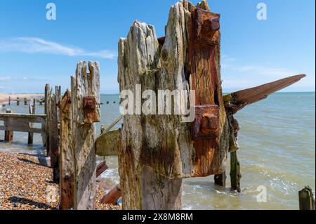 Abgenutzter, groyne Pfostenkopf mit stark verwittertem Holz, rostigen Bolzen und Rostflecken im Rye Harbour Nature Reserve an einem hellen, sonnigen Tag. Stockfoto