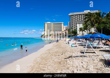 HONOLULU, HAWAII, USA - AUG. 20 2023: Überfüllter Waikiki Beach in Honolulu mit Touristen, die auf den hawaiianischen Inseln sonnen und schwimmen. Stockfoto