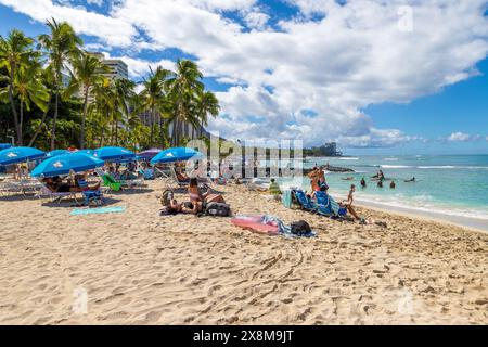 HONOLULU, HAWAII, USA - AUG. 20 2023: Überfüllter Waikiki Beach in Honolulu mit Touristen, die auf den hawaiianischen Inseln sonnen und schwimmen. Stockfoto