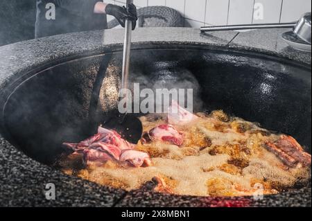 Der Küchenchef kocht in Usbekistan in Taschkent Lammfleisch in einem kochenden Kessel für das traditionelle orientalische usbekische Pilaw Stockfoto
