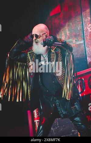 Eine Reihe von elektrisierenden Fotos von Judas Priest live, die den legendären Heavy Metal-Stil, die dramatische Beleuchtung und die intensive Performance-Energie hervorheben. Stockfoto