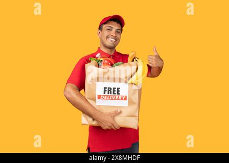Liefermann in rotem Hemd, der eine Tasche mit Essen hält Stockfoto
