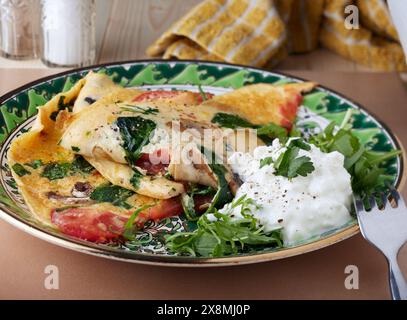 Omelettscheiben mit Rakete und Hüttenkäse. Stockfoto