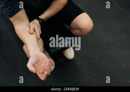 Nahaufnahme eines nicht erkennbaren Sportlers, der beim Workout mit Langhantelgewicht im Fitnessstudio Verletzungen und Armverletzungen erlitten hat. Sportlicher Mann Stockfoto