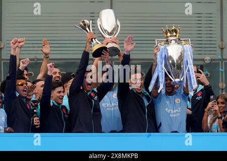 Kyle Walker aus Manchester City und seine Teamkollegen feiern mit der Trophäe der Premier League, während Rodri während einer Parade in Manchester mit der Trophäe der FIFA Club World Cup feiert, nachdem sie ihren vierten Titel in Folge und ihren sechsten Titel in sieben Jahren gewonnen haben. Bilddatum: Sonntag, 26. Mai 2024. Stockfoto