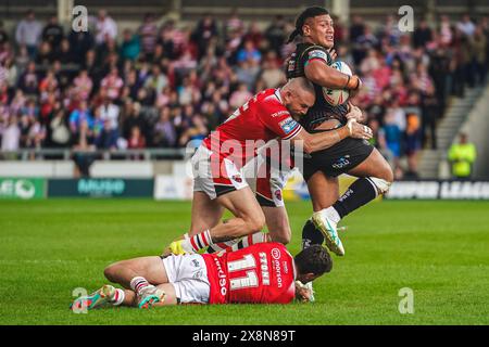 Salford, Manchester, Großbritannien. Mai 2024. Super League Rugby: Salford Red Devils gegen Wigan Warriors im Salford Community Stadium. PATRICK MAGO wird von SAM STONE um die Beine und BRAD SINGLETON um die Spitze gekämpft. James Giblin/Alamy Live News. Stockfoto