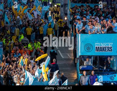 Manchester, Großbritannien. Mai 2024. Die Siegesparade von Manchester City zieht durch Deansgate im Stadtzentrum. Fans säumten die Strecke im Stadtzentrum, um die Parade zu sehen, um den historischen Triumph ihres Vereins in der Premier League zu feiern. Manchester City war die erste Mannschaft in der Geschichte des englischen Fußballs, die vier Titel in der Liga gewann, dank eines Sieges 3-1 gegen West Ham United am vergangenen Sonntag (19. Mai). Manchester UK Bild: Garyroberts/worldwidefeatures.com Credit: GaryRobertsphotography/Alamy Live News Stockfoto