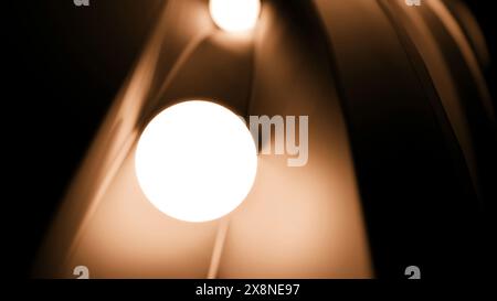 Bewegliche glühende 3D-Kugeln. Design. 3D-Kugeln leuchten und Rollen auf der Schiene. Animation mit 3D-Kugeln, die im Dunkeln leuchten und sich im Tunnel bewegen Stockfoto