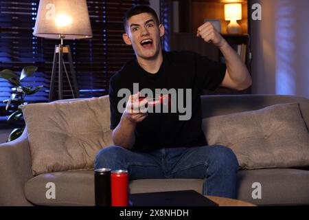 Emotionaler Mann, der Videospiele mit dem Controller zu Hause spielt Stockfoto
