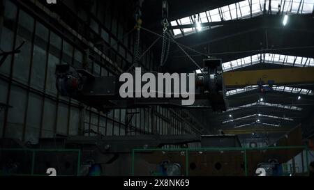 Flachwinkelansicht eines großen Metalldetails an Aufhängungen im Werk. Clip. Aufhängungssysteme mit Ankern zum Tragen von Lasten im Werk. Stockfoto