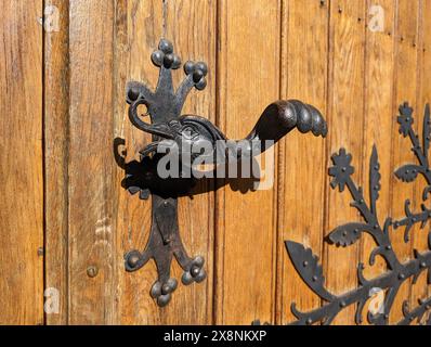 Retro Vintage Türgriff Nahaufnahme. Alte Holztür mit schönen Retro-Türknöpfen in Form eines Entenkopfes und Flügels. Selektiver Fokus. Stockfoto