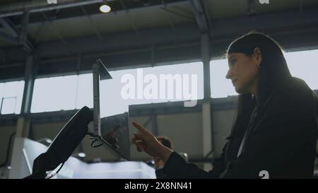 Frau mit Bedienpult für Robotermaschinen. Medien. Bedienfeld stellt den Betrieb der Robotermaschine auf dem Sensorfeld ein. Berühren Sie das Bedienfeld mit Aufgaben für Stockfoto