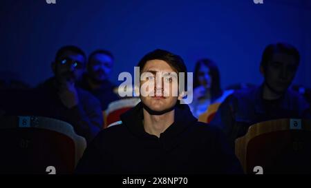 Publikum im Theater oder Kino. Medien. Porträt eines Mannes und Silhouetten hinter Applaus. Stockfoto