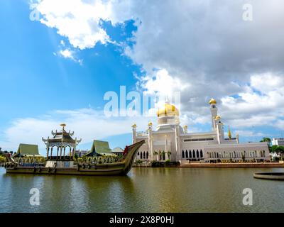 Wunderschöne Szene der schwimmenden masjid-Architektur der Omar Ali Saifuddien Moschee mit zeremoniellem Schiff auf blauem Himmel Hintergrund, Wahrzeichen in Bandar Seri BE Stockfoto