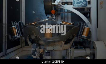 Rotierende Maschine mit Kupferdrahtwicklung. Kreativ. Automatisierte Maschine zum Wickeln von Kupferdraht auf Spulen. Drehen mehrerer Spulen zum Einwickeln von Drähten Stockfoto