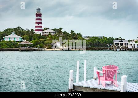 Pinkfarbener Adirondack Stuhl am Pier gegenüber dem Leuchtturm des Elbow Reef. Stockfoto