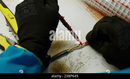 Nahaufnahme von elektrischen Lötdrähten mit Sonderausrüstung. Kreativ. Reparaturverfahren für Kabel. Stockfoto