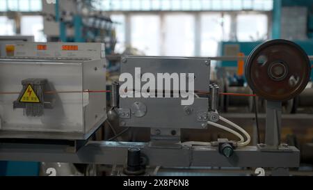 Rotierende Rollen mit Kupferdrähten. Kreativ. Metalldrahtspule dreht sich auf der Maschine. Stockfoto