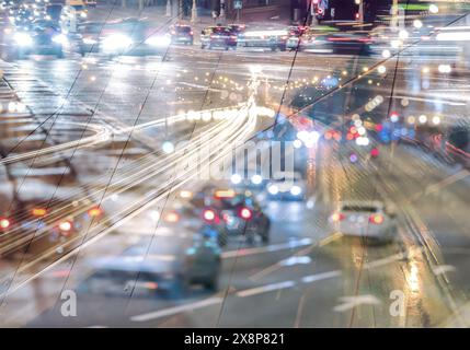 Lange Belichtungsspuren von sich bewegenden Autos. Nachtverkehr in der Stadt. Mehrfach belichtetes Bild. Stockfoto